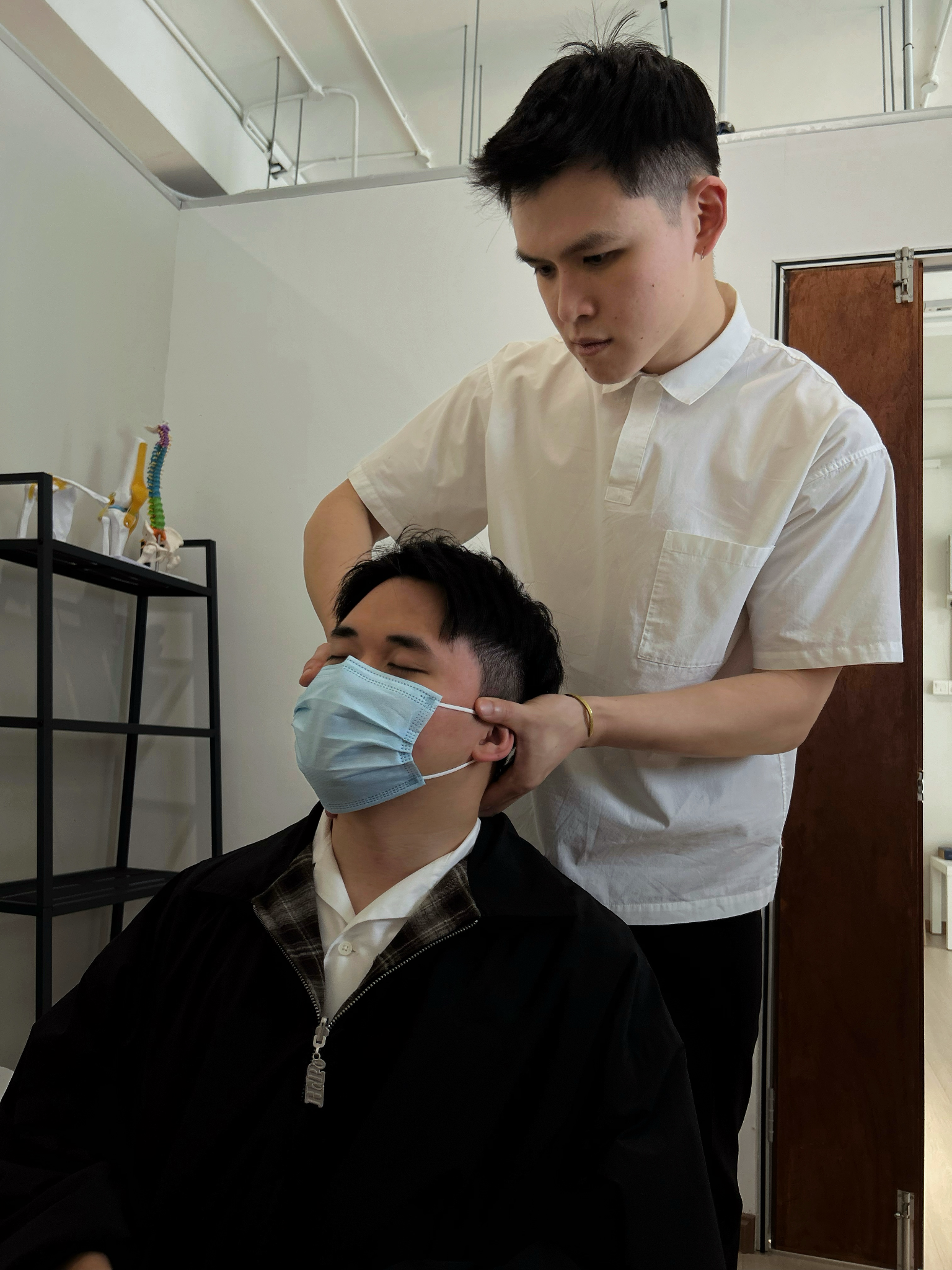 Chiropractor examining a patient's neck and posture