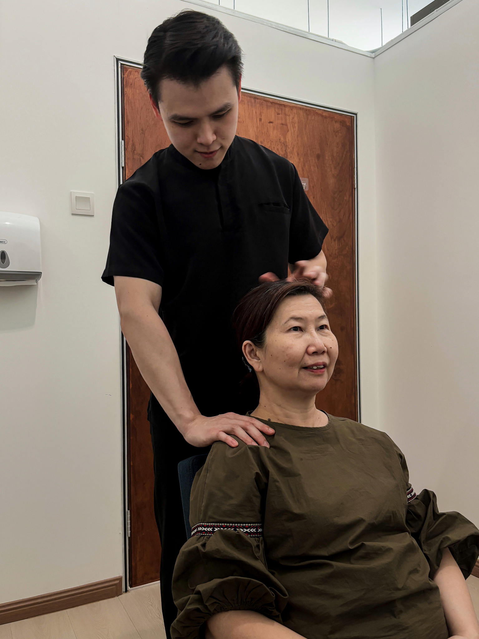Chiropractor working with a seated patient at Ascend Chiropractic